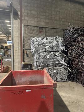 Scrap Metal Recycling Facility with Stacked Aluminum and Red Bin