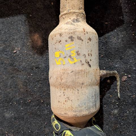 Barrel of scrap catalytic converters, tagged for recycling